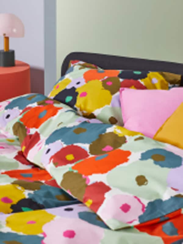A SLATTUM bed dressed with floral MURREVA duvet cover and floran MURREVA pillowcases.