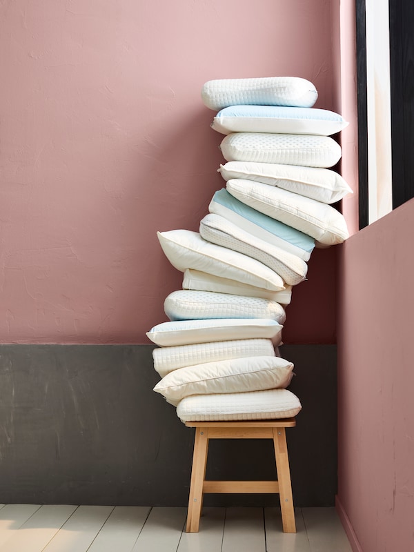 Timbunan bantal di atas bangku termasuk Bantal SKOGSFRÄKEN & NORDSTÅLÖRT Bantal ergonomik