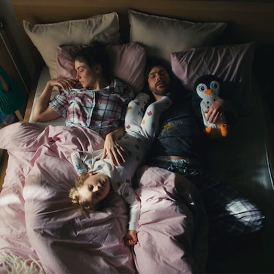 Parents and child sleeping a bed
